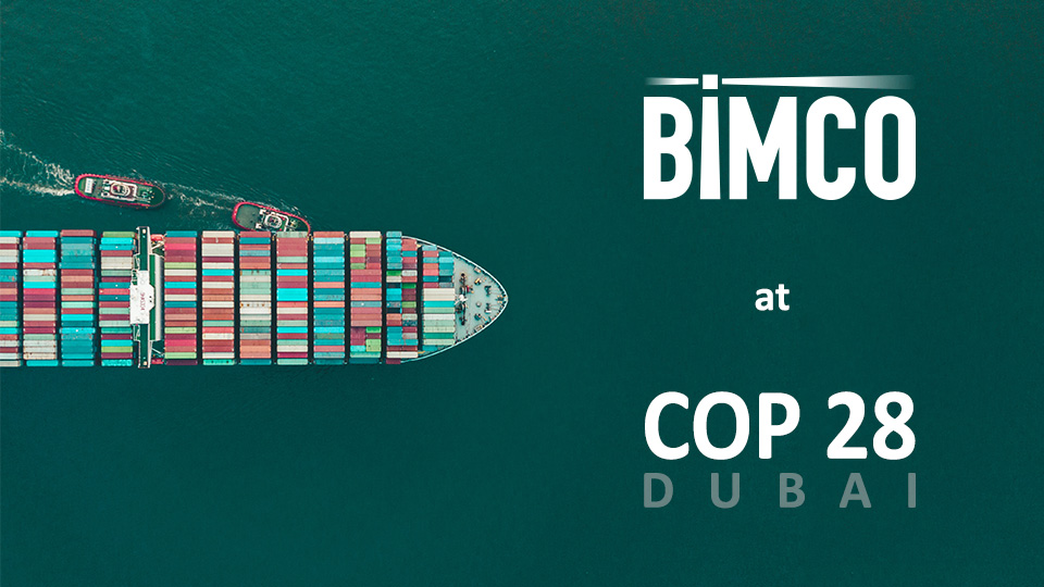 Container ship sailing with "BIMCO at COP28 Dubai" text overlaid