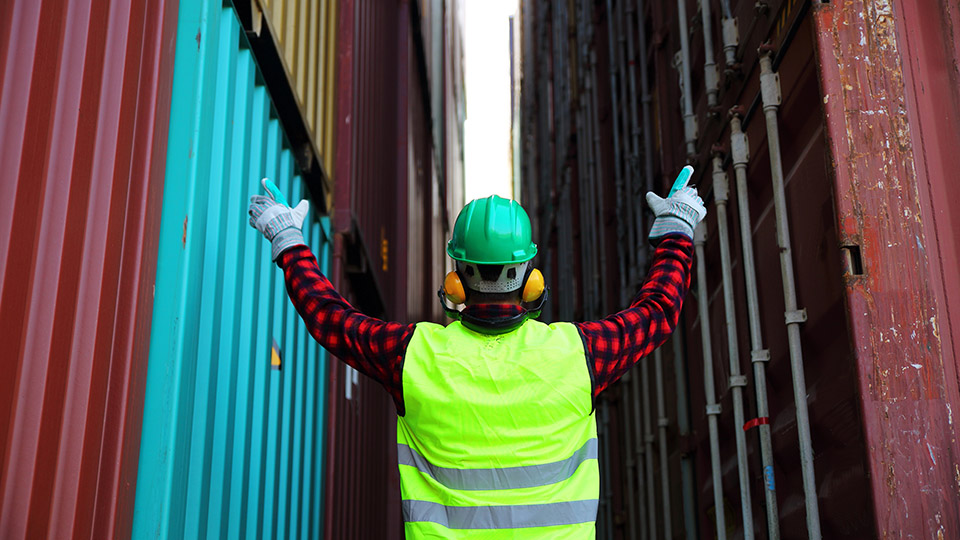 Dock worker between two sea containers