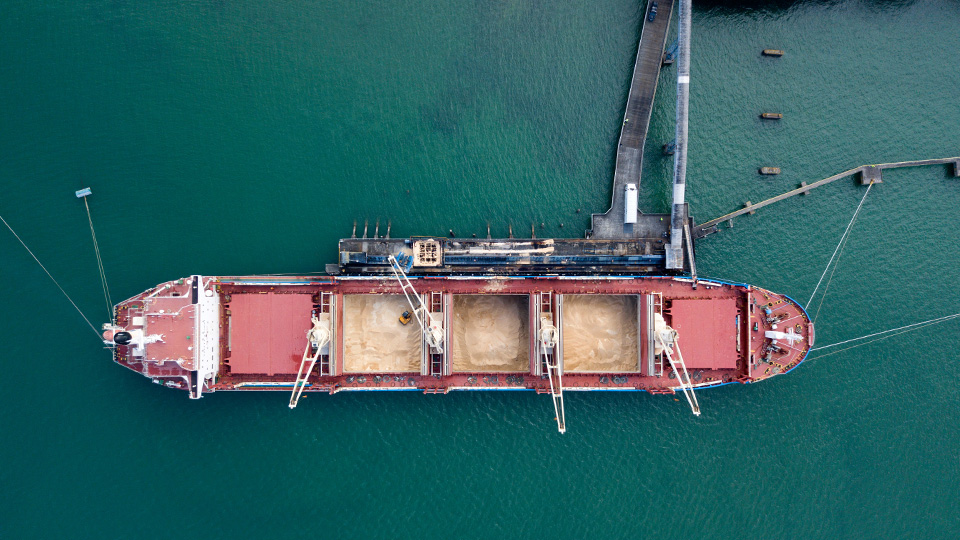 Aerial top-down view of sugar being offloaded from large bulker ship