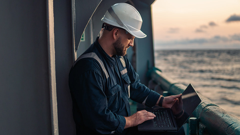 Ship crewman looking at a computer laptop