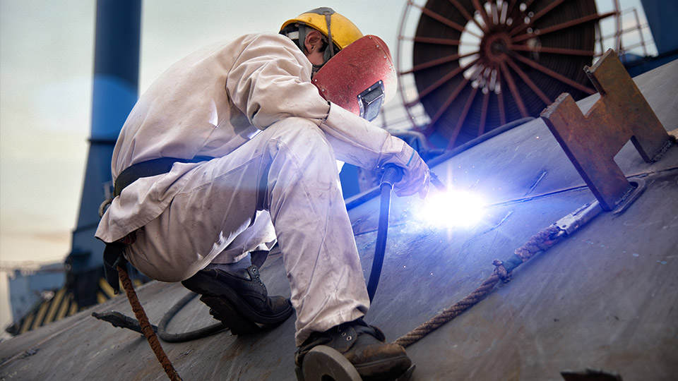 Ship worker welding steel