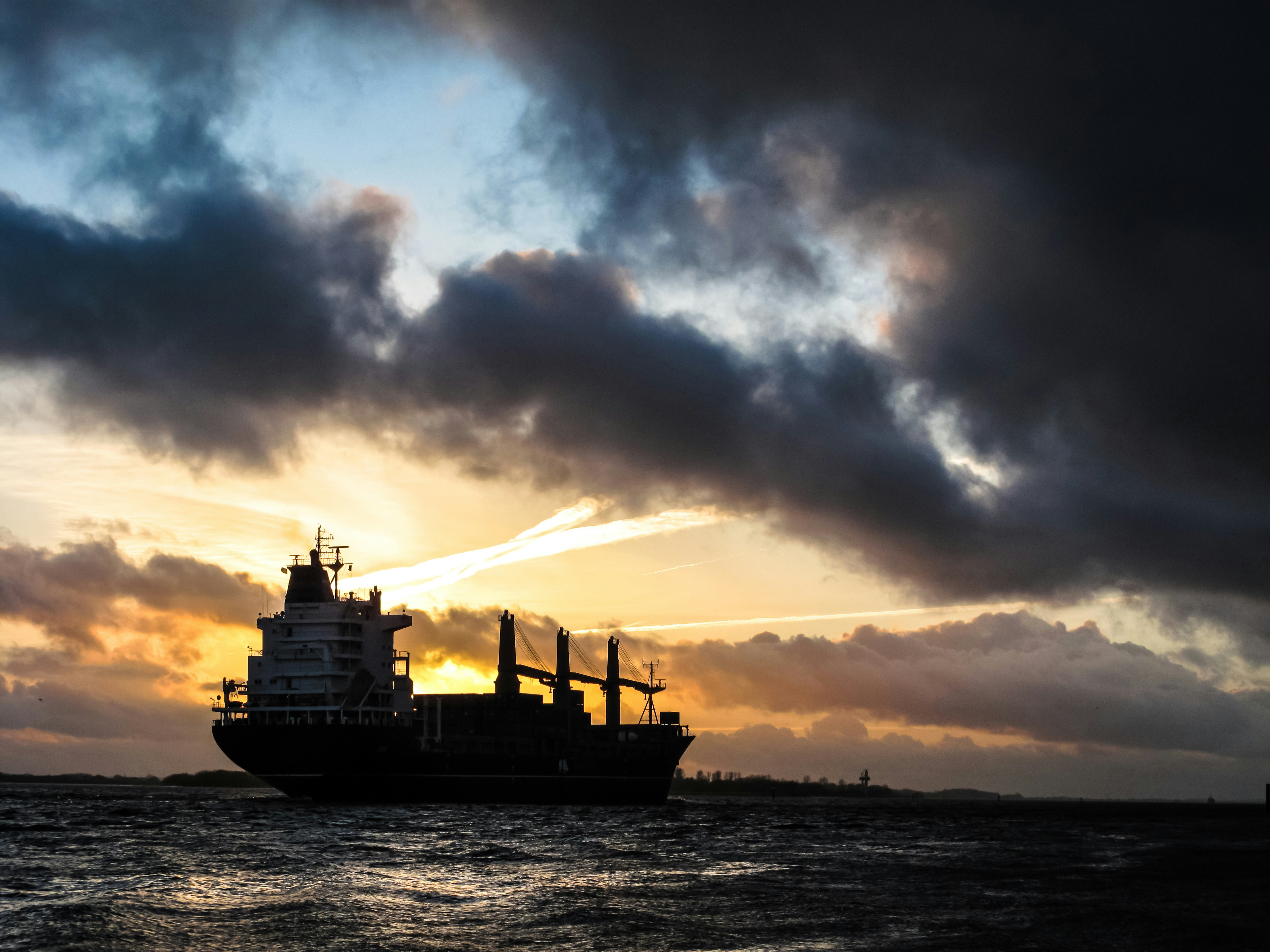 A bulk carrier ship with a stormy sky