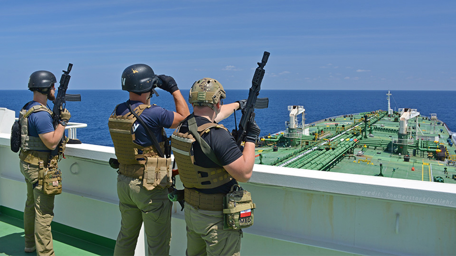 Three armed guards on deck of a tank ship
