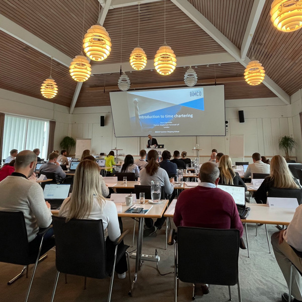 people in a conference room with a speaker at the front on a podium