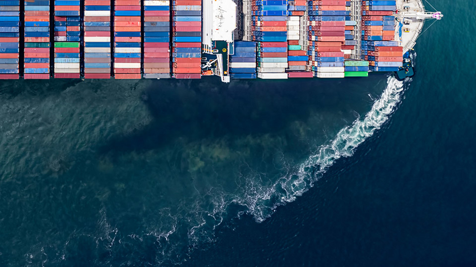 Container ship seen from above showing bow wave