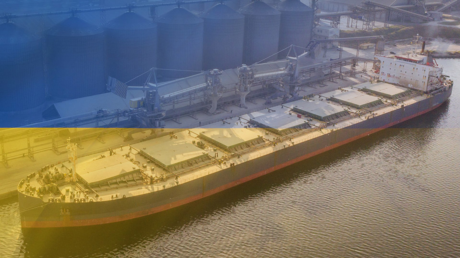 Dry bulk carrier ship at terminal with Ukrainian flag colours superimposed