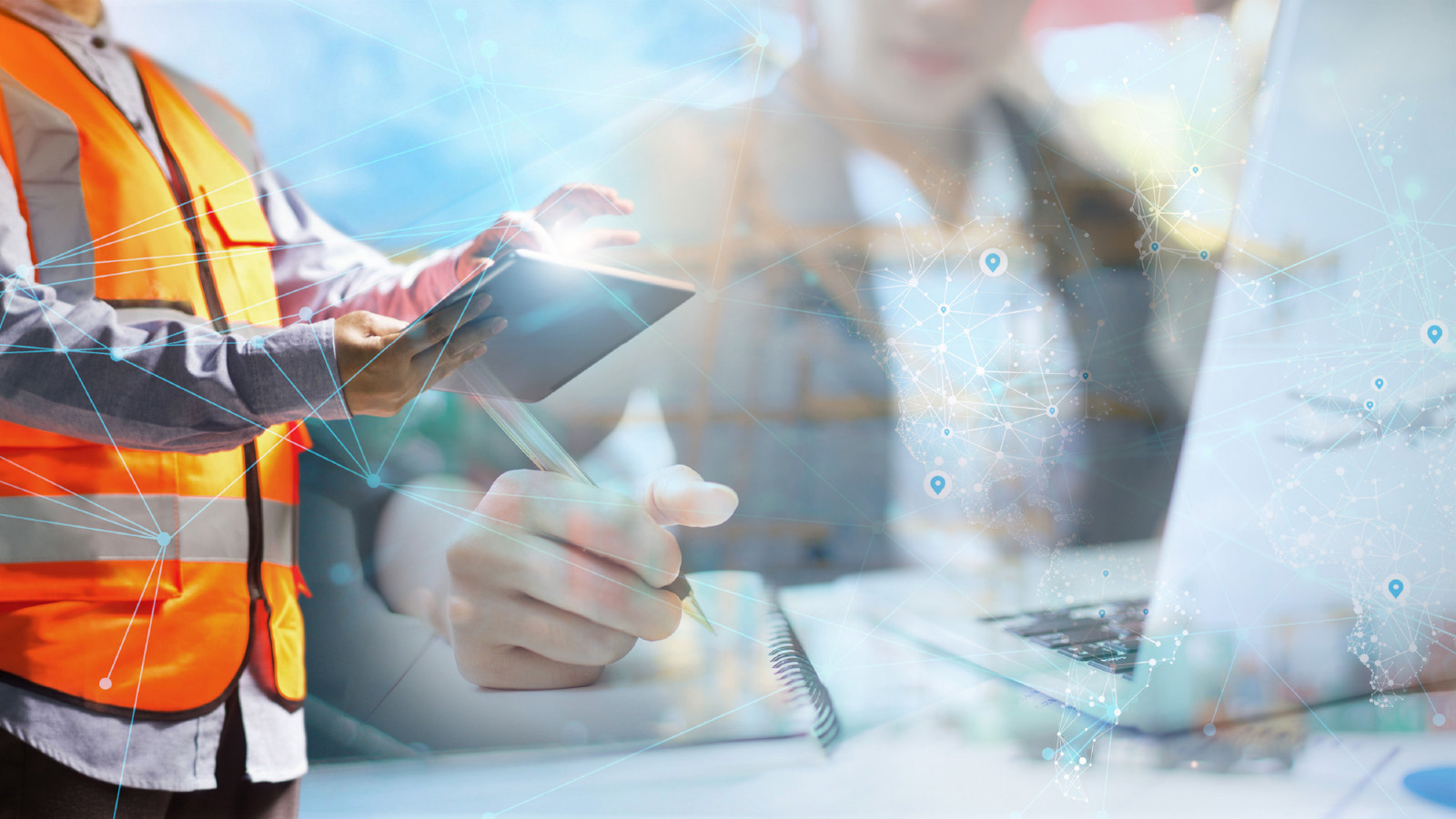 person in orange safey vest typing on a computer