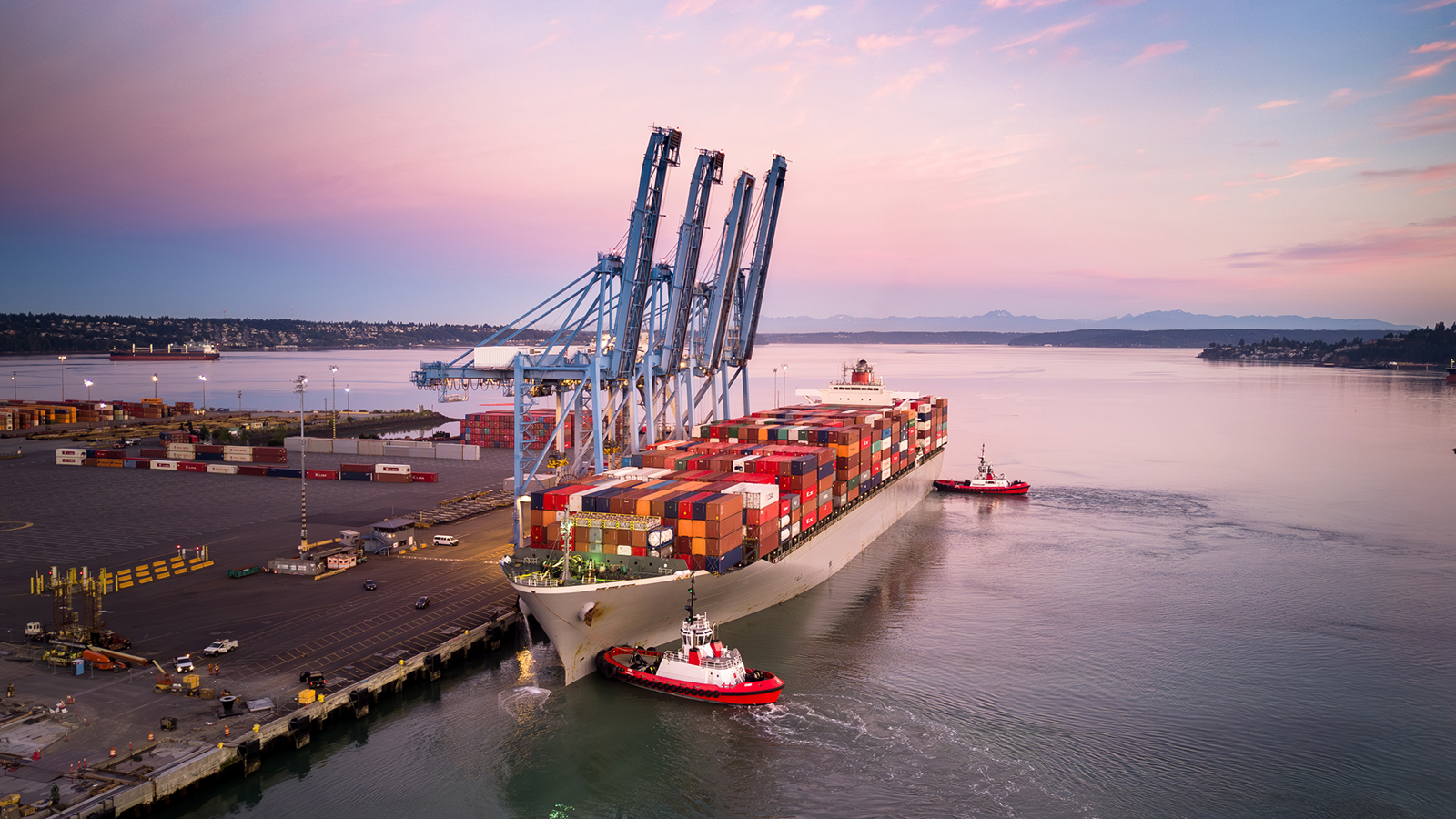 A container ship at berth in Tacoma, with cranes alongside ready to unload containers